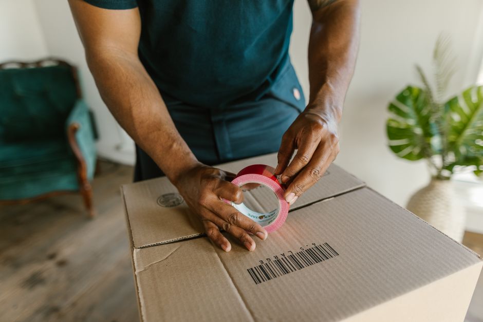 Movers taping cardboard moving boxes securely