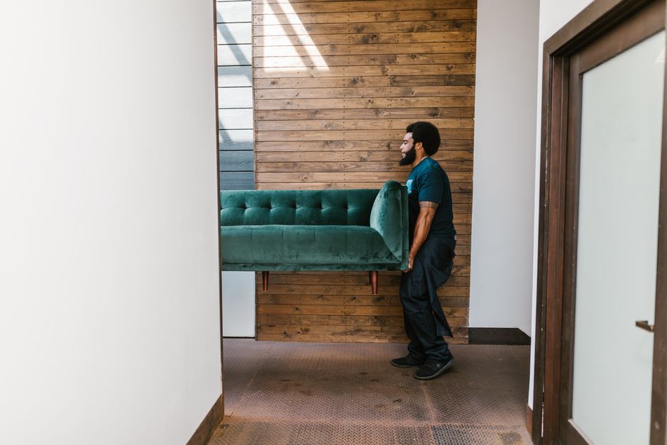 Professional movers carrying a heavy sofa carefully